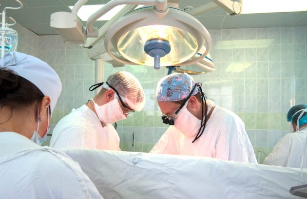 a group of doctors performing surgery in a hospital.
